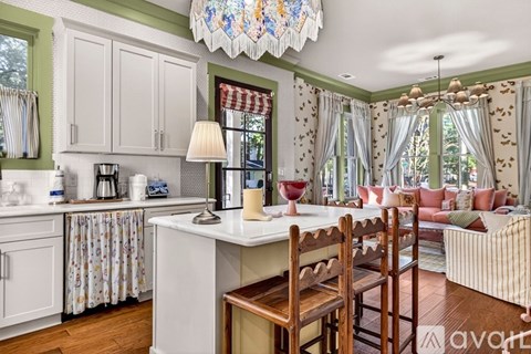 A kitchen with a table and chairs in front of a window.