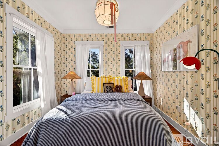 A bedroom with a large bed and two lamps.