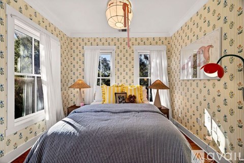 A bedroom with a large bed and two lamps.