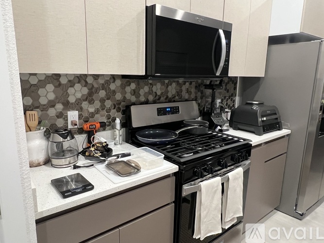 A kitchen with a black stove top oven and a black microwave above it.