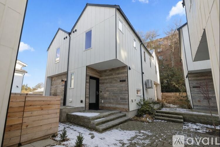 A modern house with a wooden fence and a black door.