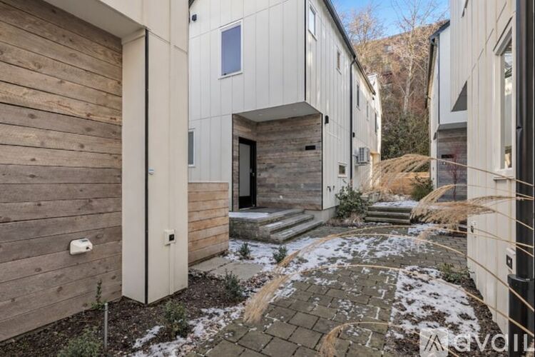A snowy courtyard surrounded by wooden buildings.