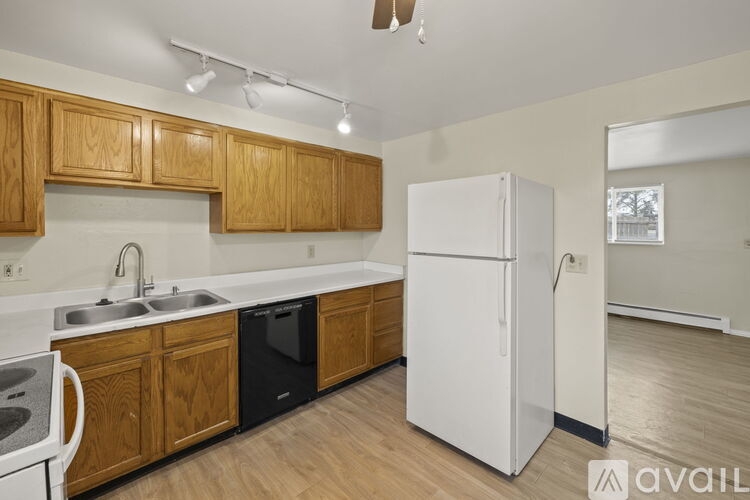 A kitchen with wooden cabinets and a white refrigerator.