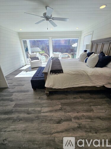A bedroom with a large bed and a ceiling fan.