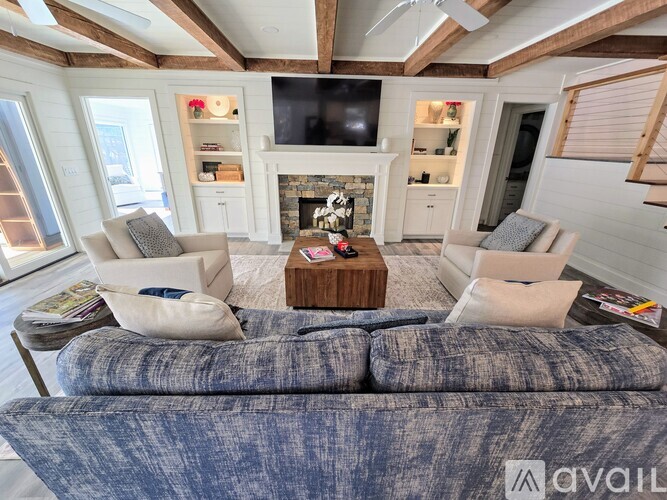 A living room with a grey couch and a fireplace.