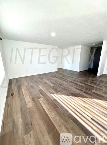 A room with wooden flooring and a white wall with the word INTEGRITY on it.