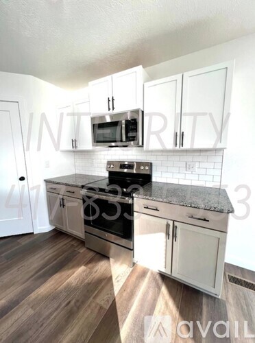 A kitchen with white cabinets and a black stove top oven.