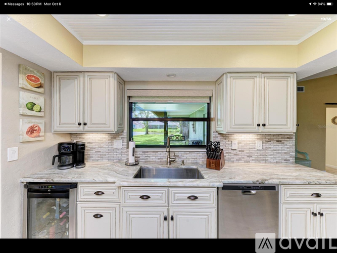 A kitchen with white cabinets and a marble countertop.