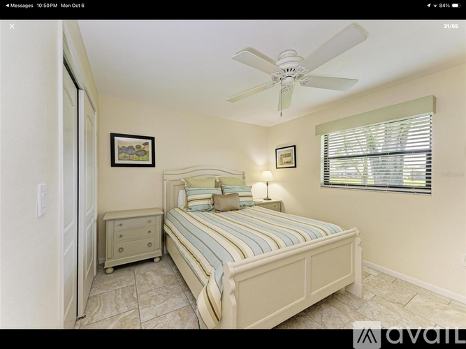 A bedroom with a bed, nightstand, and a ceiling fan.