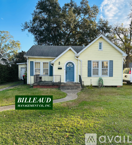 A yellow house with a blue door and windows is for sale.