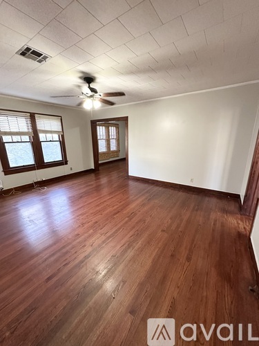 A room with wooden floors and a ceiling fan.