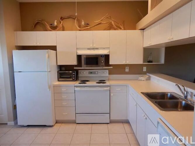 A kitchen with white appliances and cabinets.