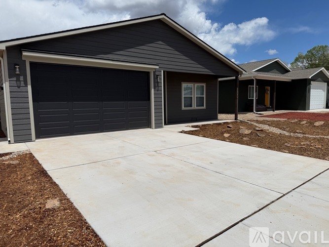 A house with a grey garage door is for sale.
