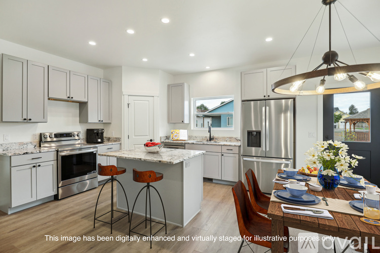 A modern kitchen with a dining table set for two.