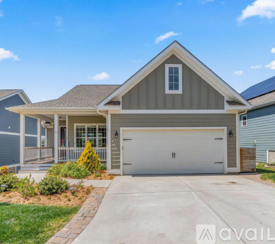 A house with a garage and a driveway in front.