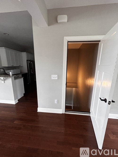 A kitchen with a white door and a white wall.