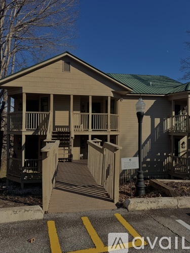 A wooden house with a green roof and a sign that says "Avalon".