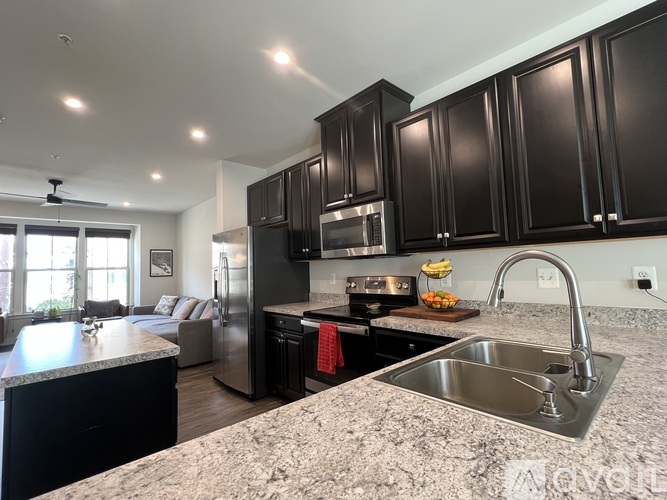 A kitchen with black cabinets and a granite countertop.