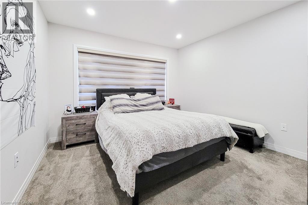 A bedroom with a bed, nightstand, and a wall art.