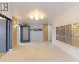 A hallway with a sign that says "The Marquette" and a row of lockers on the right side.