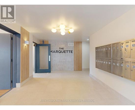 A hallway with a sign that says "The Marquette" and a row of lockers on the right side.