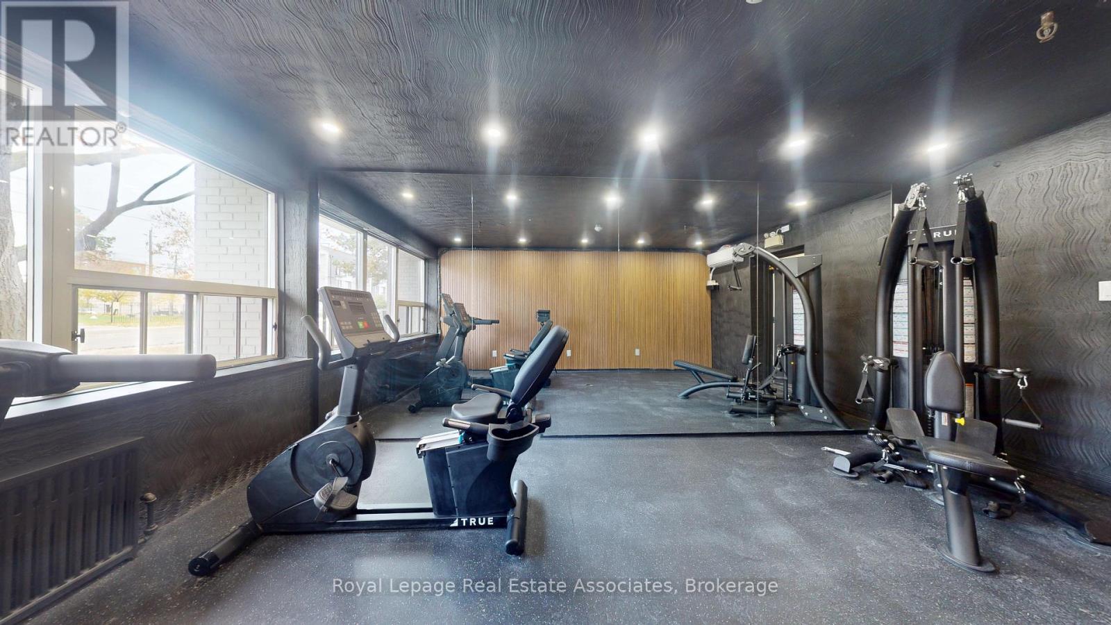 A gym with a variety of equipment including treadmills, weights and exercise machines.