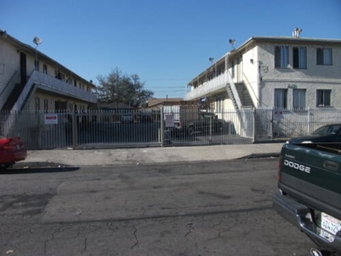 A red car is parked in front of a building with a sign that says "Dodge".