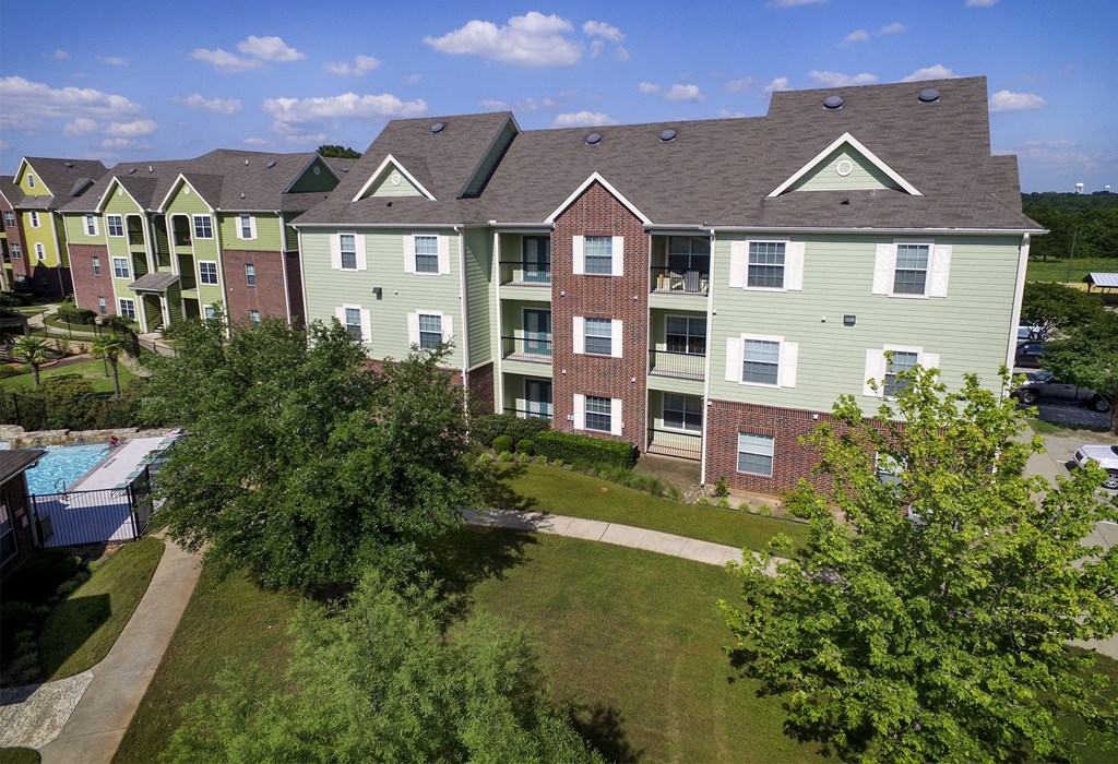an aerial view of an apartment building with a swimming pool