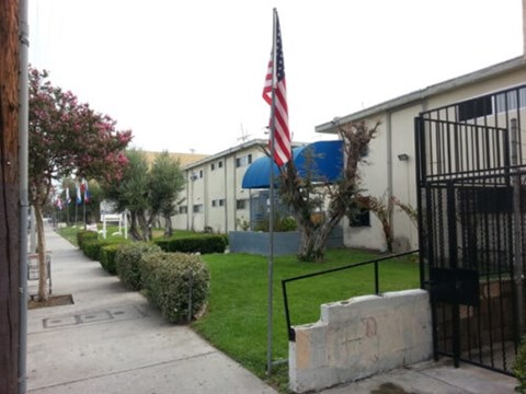 A flag is flying in front of a building with a blue roof.