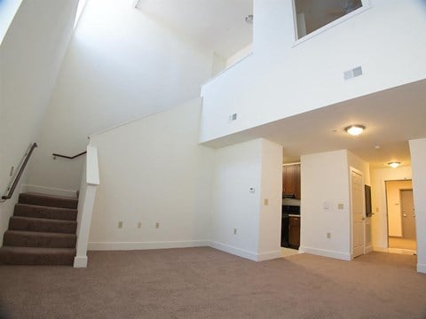 a living room with a staircase and a white wall