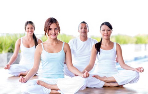 a group of people sitting in a yoga class