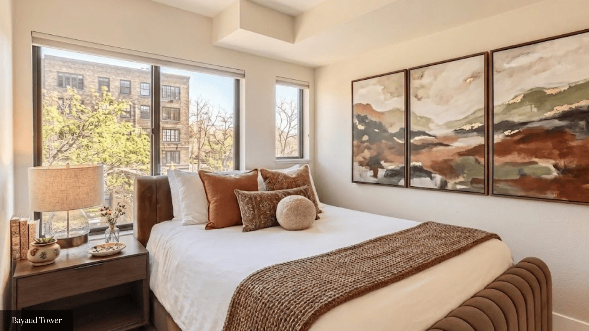 A bedroom with a large bed and a painting on the wall.