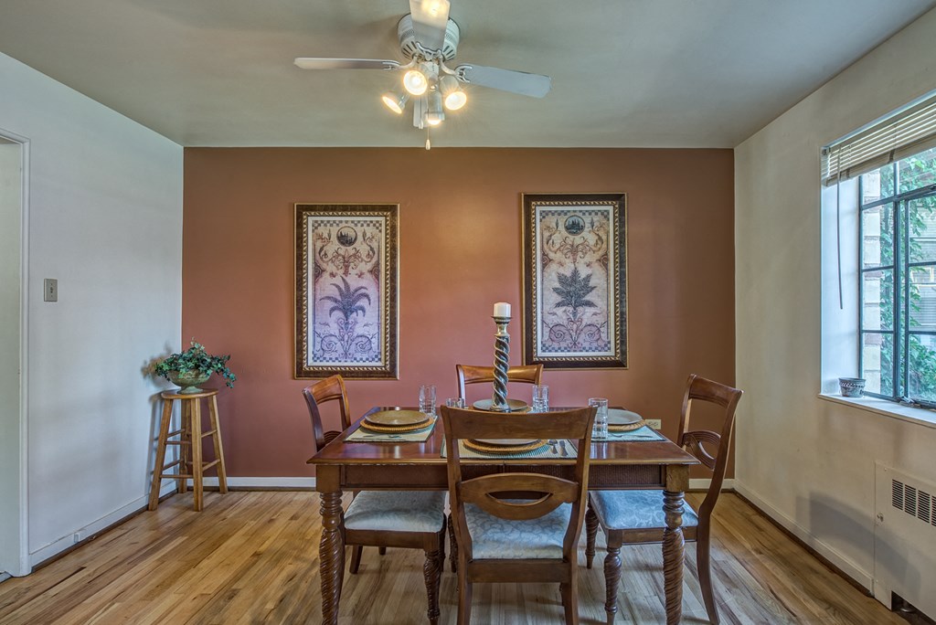 a dining room with a table and chairs and a ceiling fan