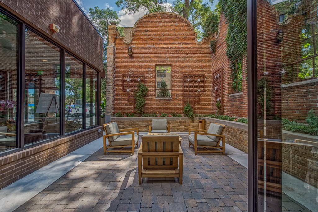 the backyard has a patio with furniture and a brick building