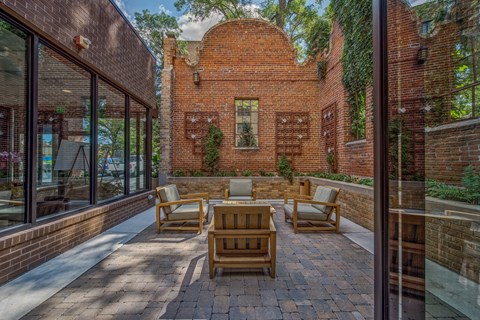 the backyard has a patio with furniture and a brick building