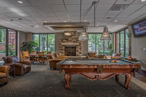 a clubhouse with a pool table and a fireplace