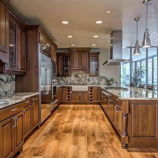 a large kitchen with wood floors and wooden cabinets