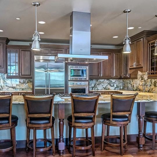 a kitchen with a bar and chairs