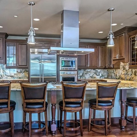 a kitchen with a bar and chairs