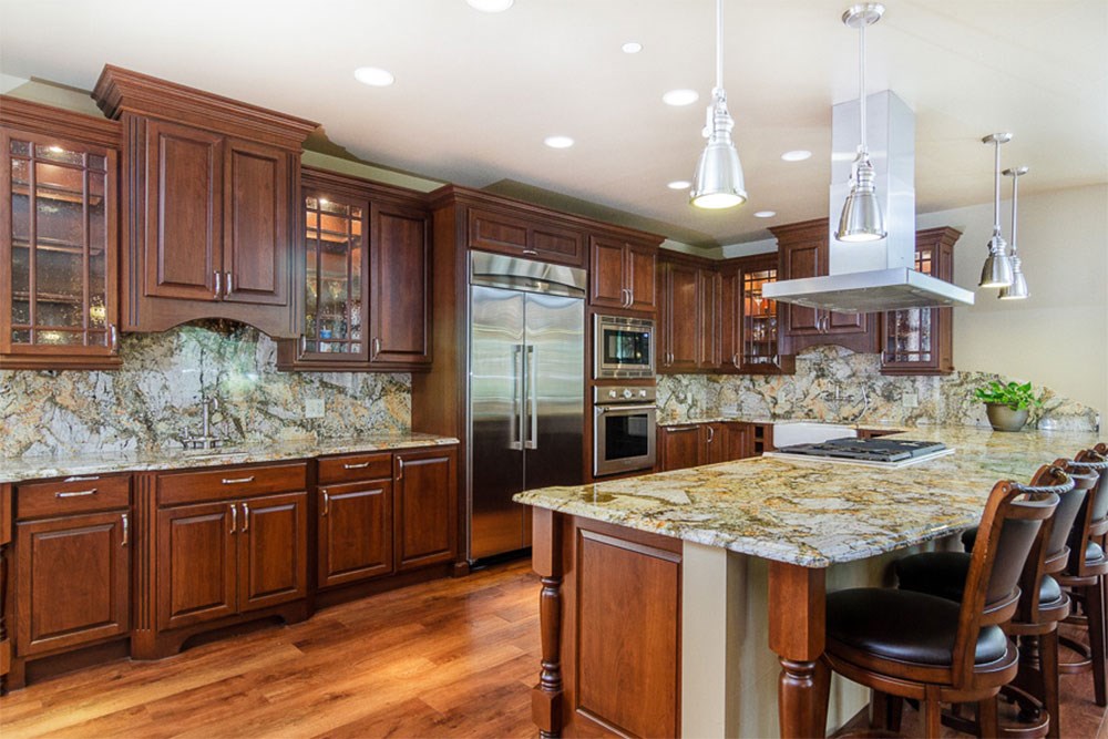 a large kitchen with marble counter tops and wooden cabinets