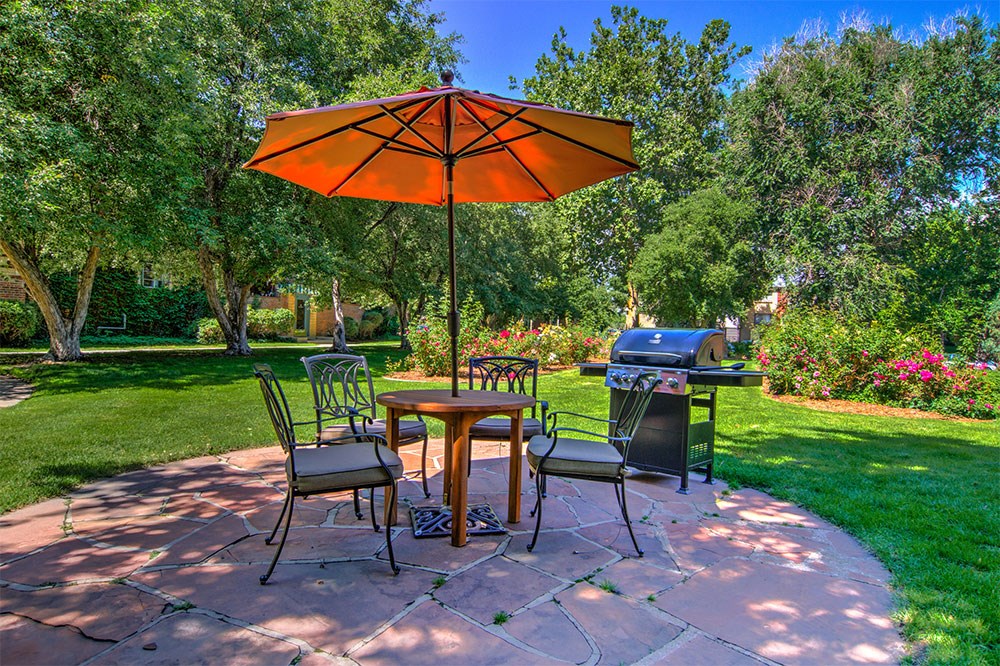 a patio with an umbrella and a table with chairs