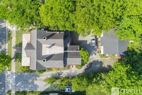 A house surrounded by trees and a driveway.