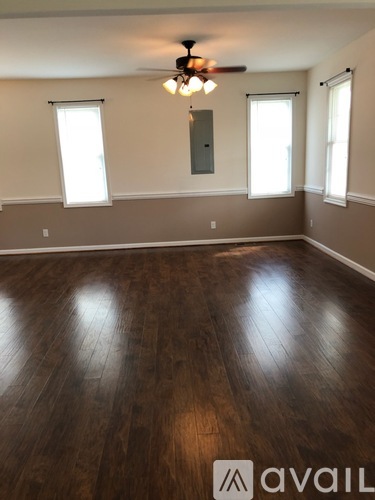 A room with wooden flooring and a ceiling fan.