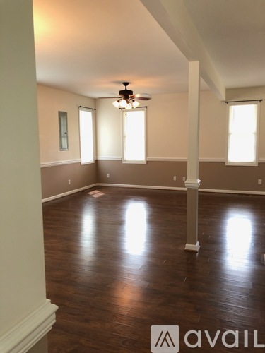A room with wooden floors and a ceiling fan.