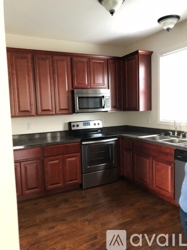 A kitchen with brown cabinets and a black stove top oven.