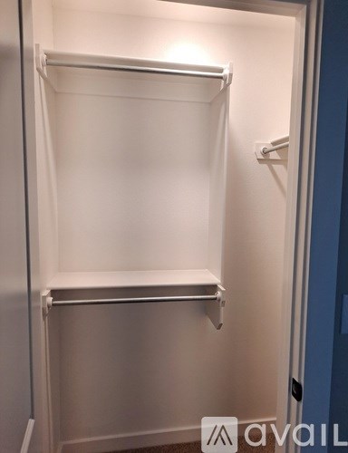 A white refrigerator with a closed door and a handle on the right side.