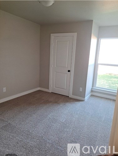 A room with a white door and carpeted floor.