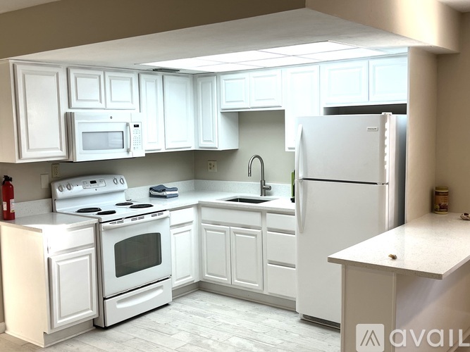 A kitchen with white appliances and cabinets.