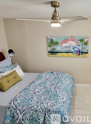 A bedroom with a bed, nightstand, and ceiling fan.
