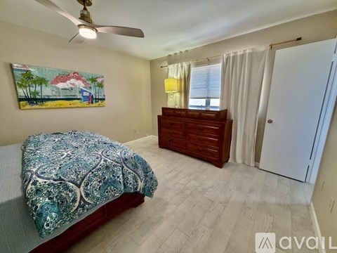 A bedroom with a bed, dresser, and window.